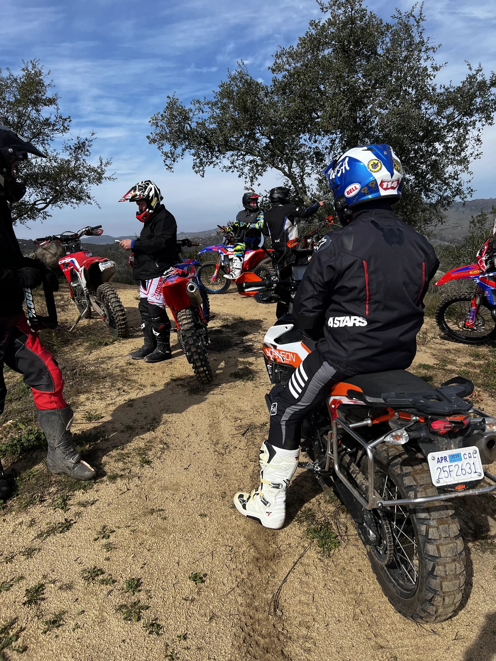 Dual-sport riders geared up on a mixed group of trail-capable bikes